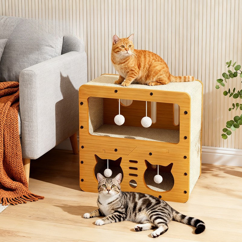 The Scratcher House next to a sofa with a ginger cat sitting on top and a tabby stretched out on the floor in front
